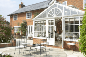 white and glass conservatory on the back of a red brick house