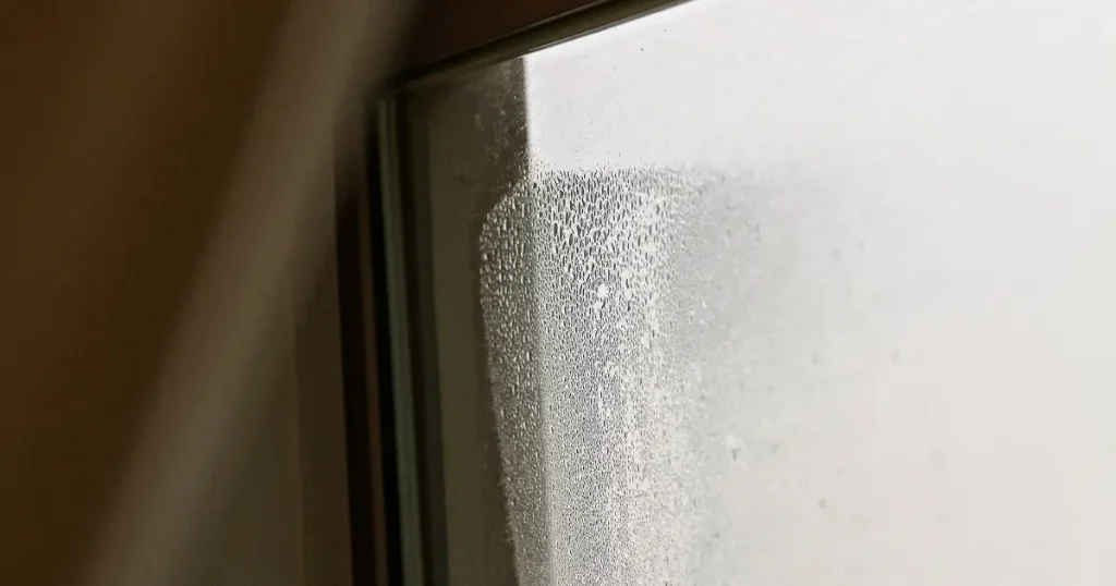 the top corner of a window filled with water caused by blown double glazing